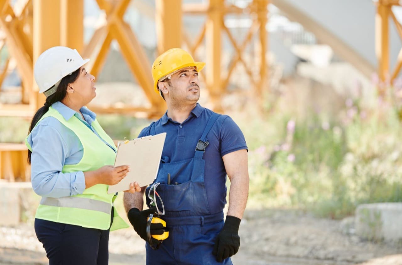 Zwei Handwerker besprechen gemeinsam die Baupläne