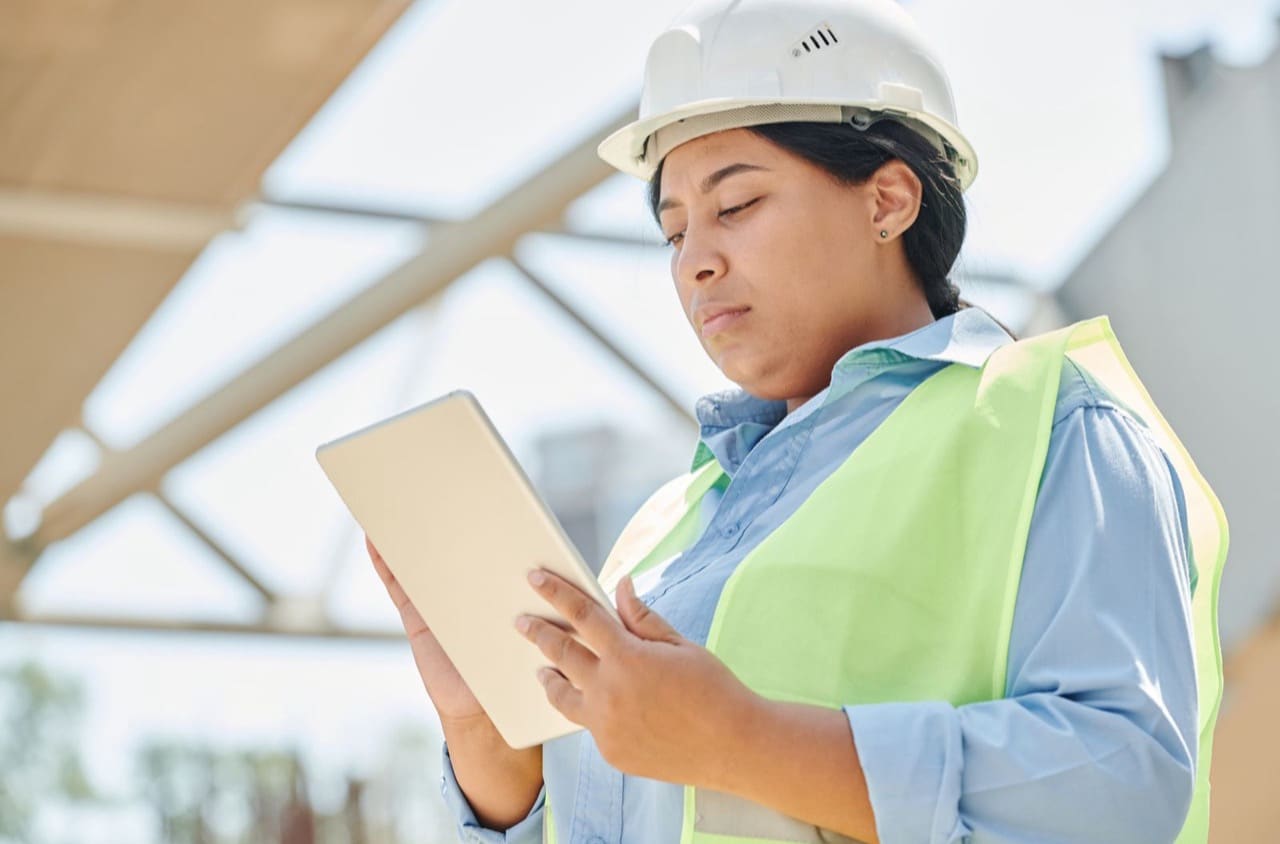 Technikerin erfasst Daten auf der Baustelle mit dem Tablet