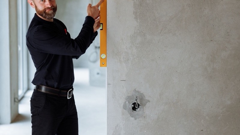 Monteur prüft eine Wand mit der Wasserwaage