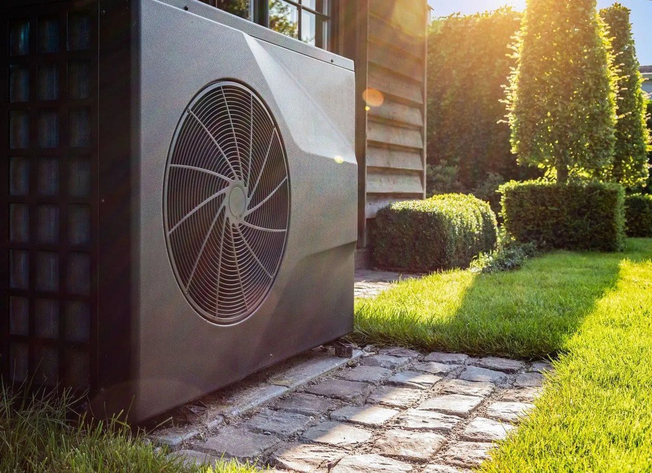 Wärmepumpe an einem Wohnhaus im Garten